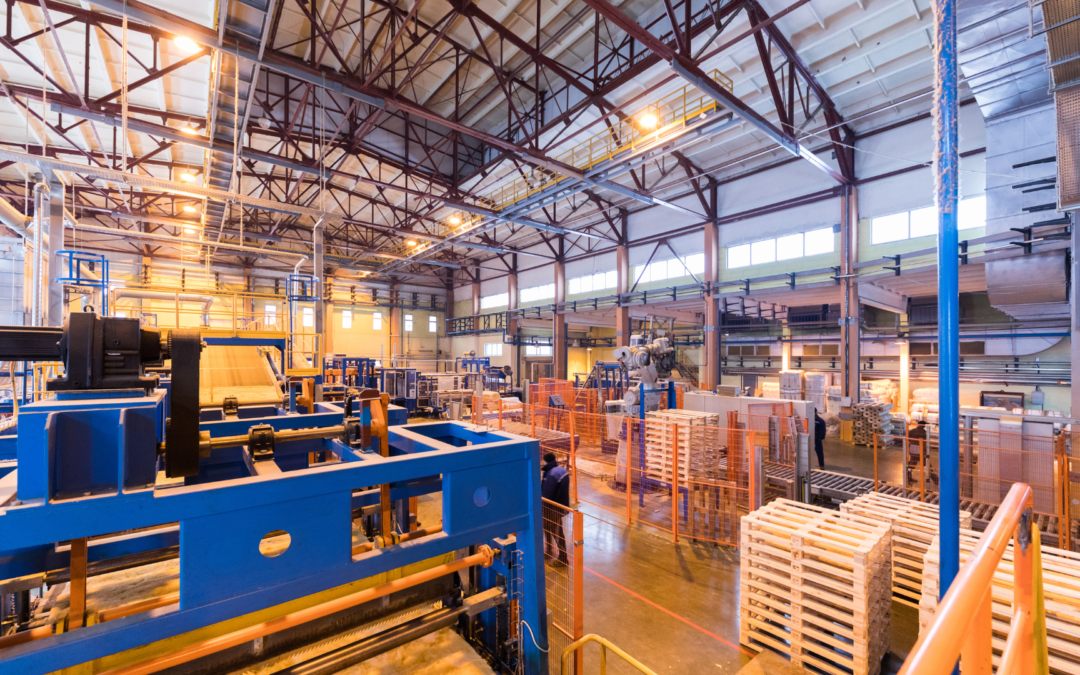 Owner standing in a modern CNC manufacturing facility reviewing business documents before selling